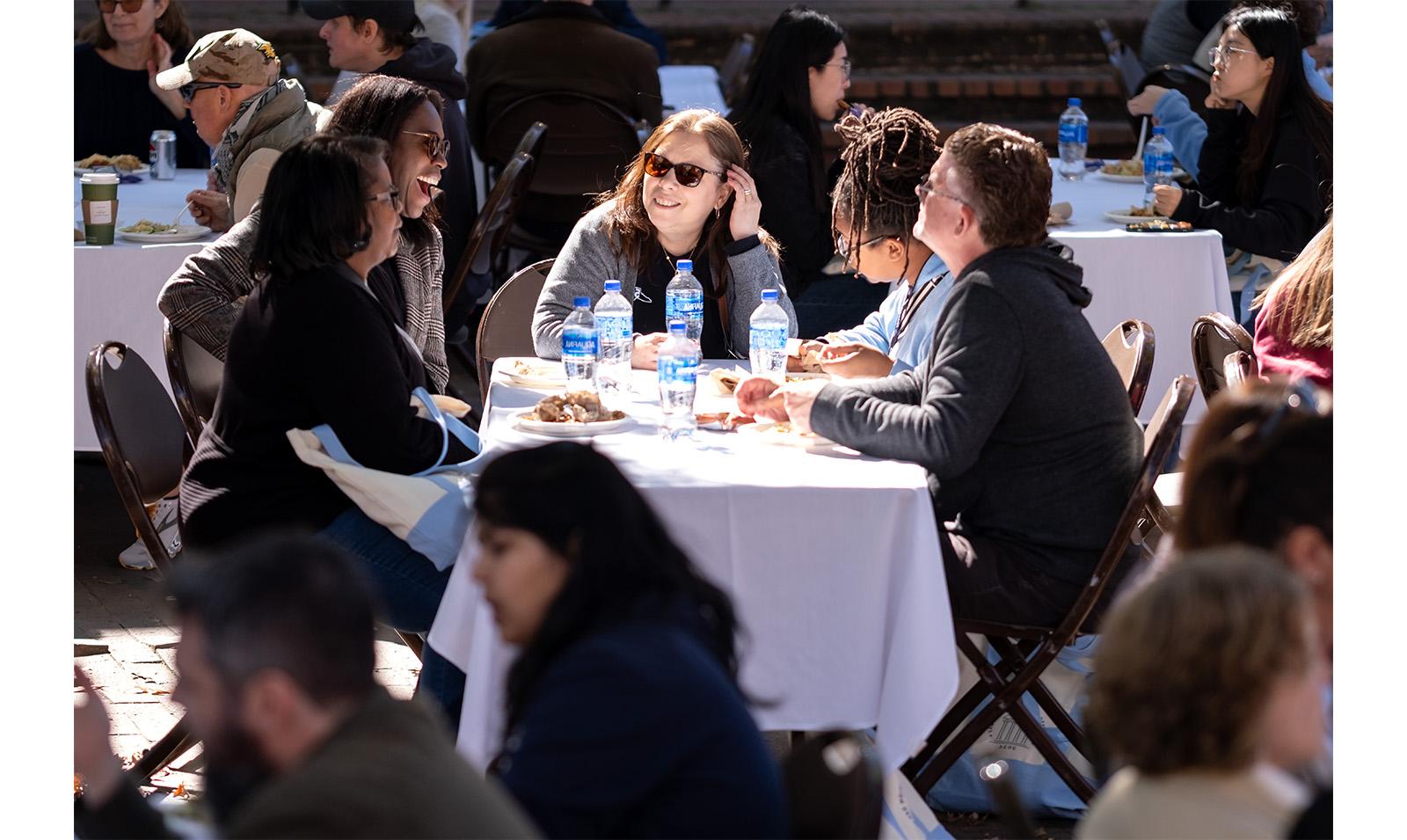 Carolina employees chat at a table with food during Employee Appreciation Day