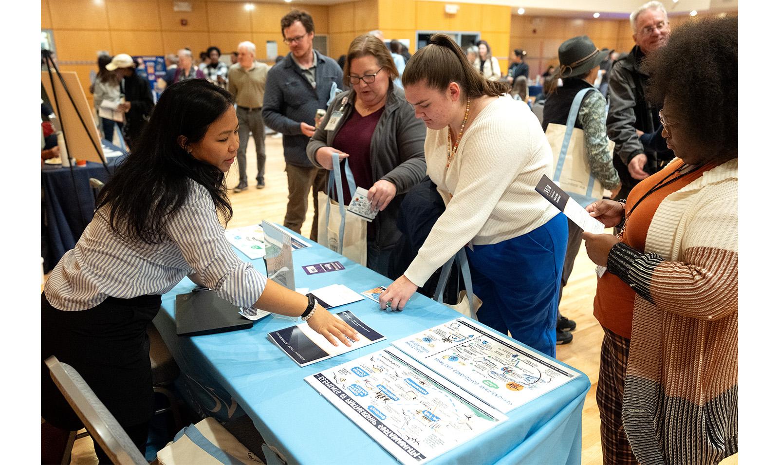 Carolina employees look at resources on a table