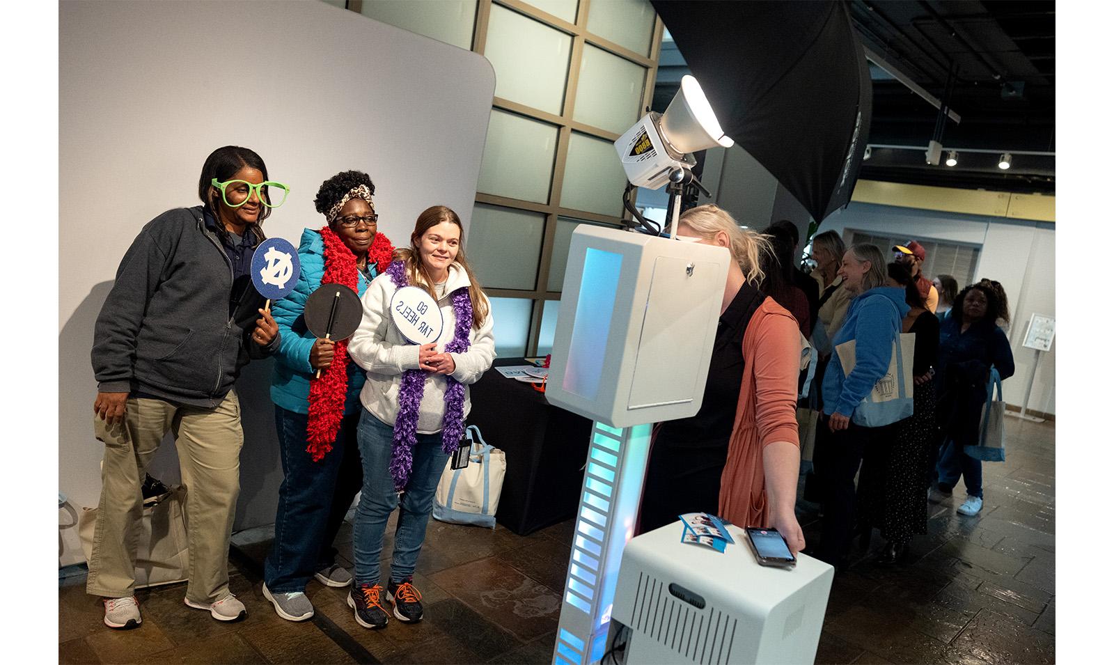 Carolina employees hold up signs at photo booth